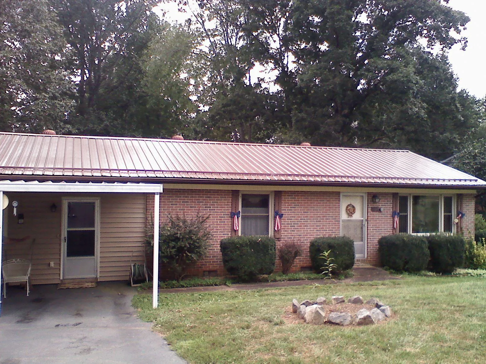 Bronze metal roof and carport on a brick ranch home — Roof Repair work by our crew in Parlin