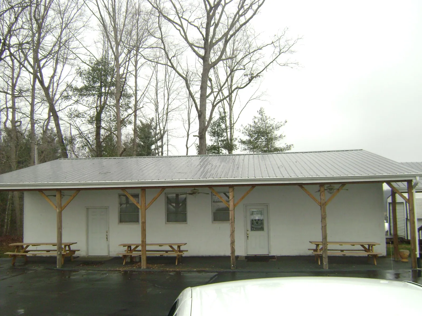 Gray metal roof over a block building with a timber post porch in Parlin